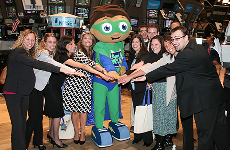 Grand Communications’ Alison Grand and Jaymie Presberg with Super Why, star of the PBS KIDS series, along with Out the Blue co-founders, show creators and executive producers, Samantha Freeman and Angela C. Santomero, bring some literary-powered fun to the trading floor of The New York Stock Exchange after ringing The Closing Bell